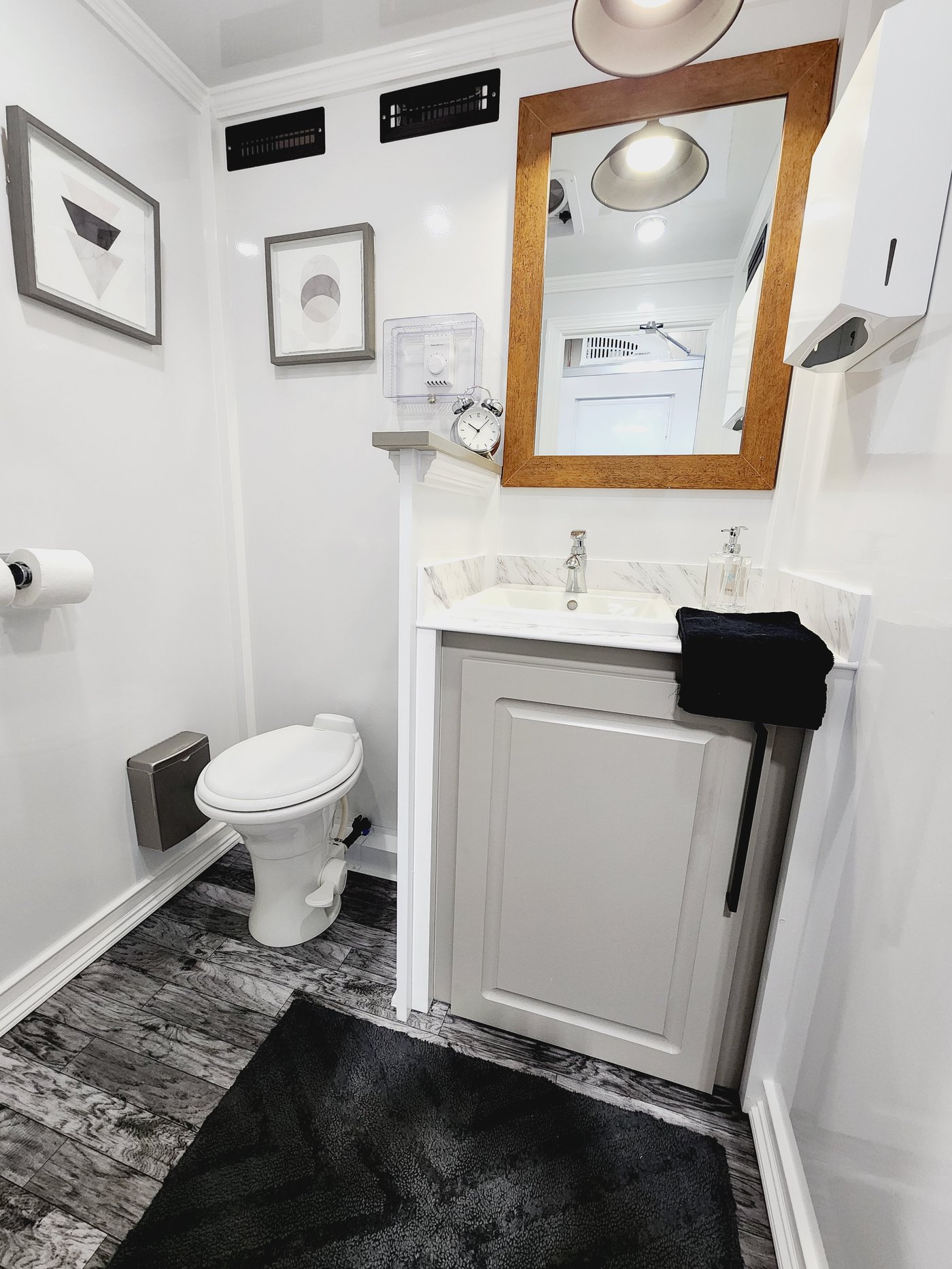 Private women's suite with marble vanity and wood-framed mirror
